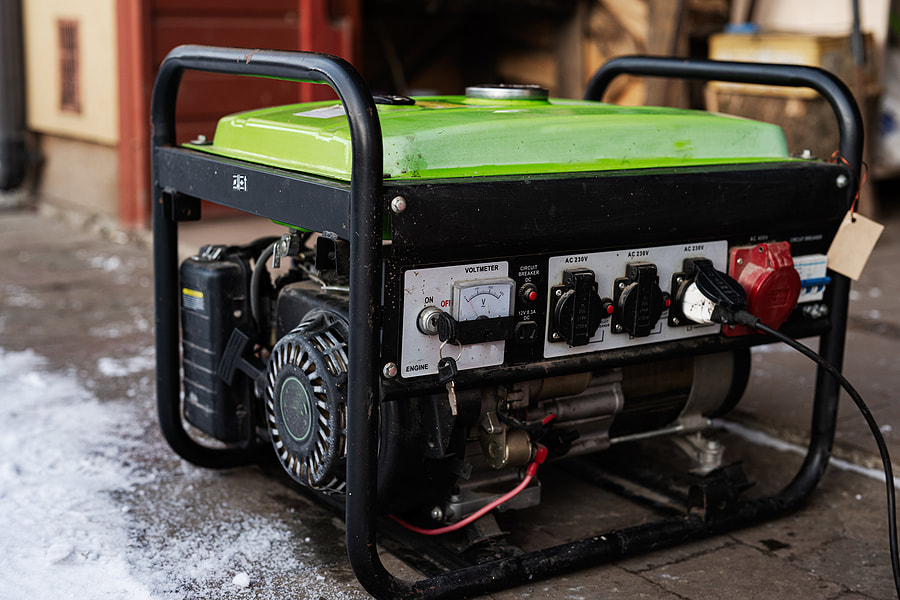 a green and black portable generator sitting on the side of a road