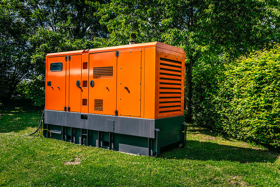 an orange and black generator sitting in the grass